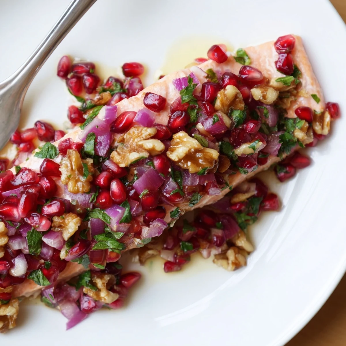 A close-up of tender baked salmon with pomegranate walnut salsa, perfect for a Mediterranean meal.