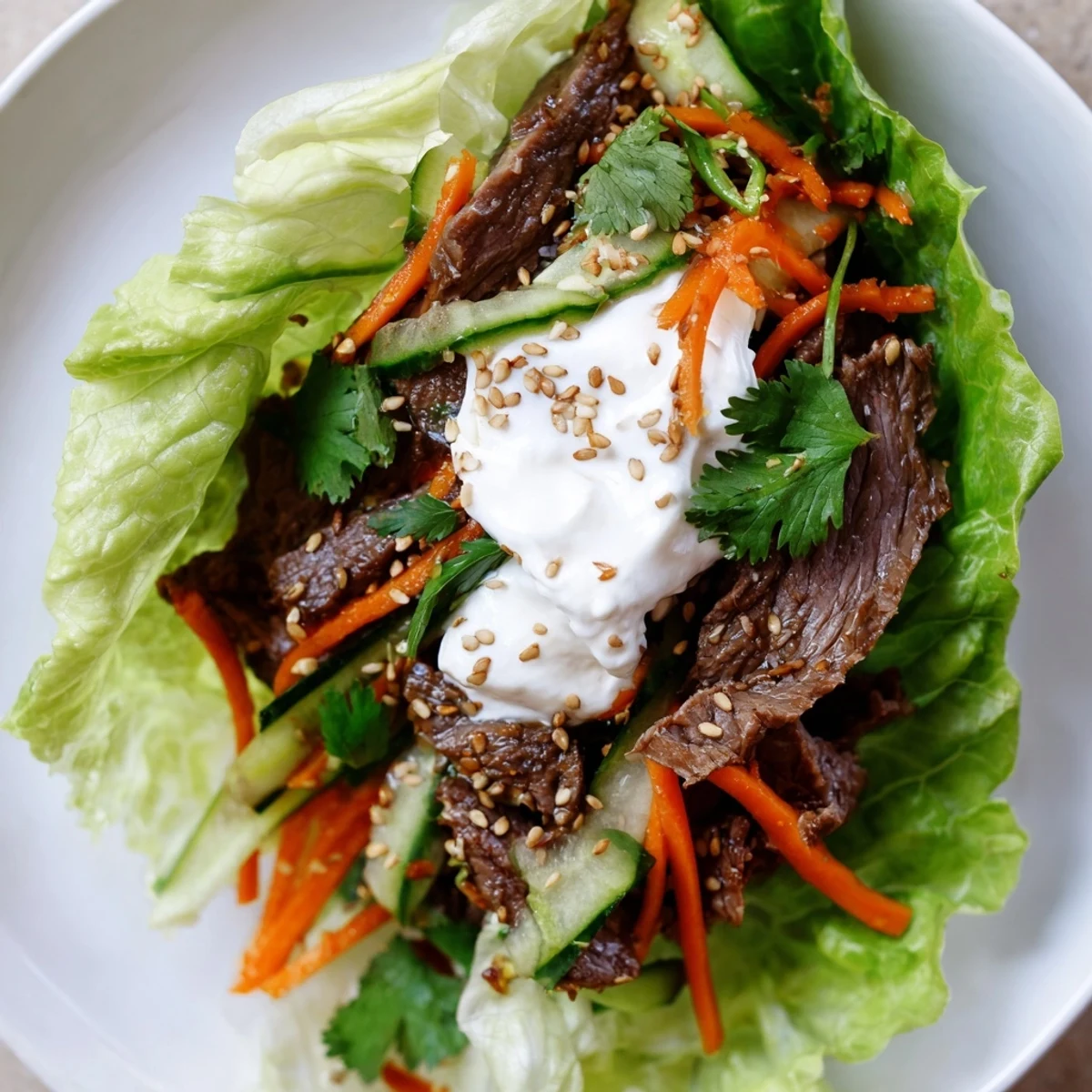 Savory Beef Wrap with Lettuce served on a wooden board, topped with sesame seeds and fresh cilantro for extra crunch.