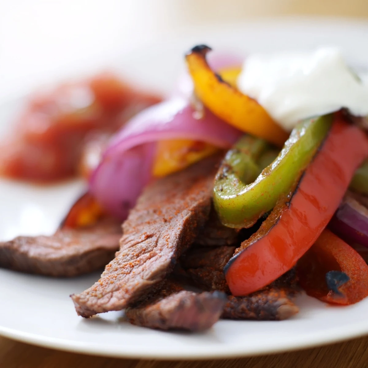 Tender beef strips and charred vegetables for Sheet Pan Steak Fajitas ready to be served with warm tortillas.