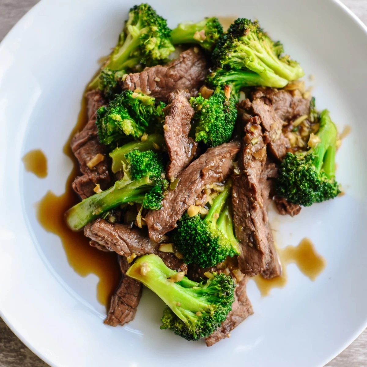 Steaming Beef and Broccoli Stir Fry with Garlic Soy Sauce glistens in a black bowl, ready to be served.