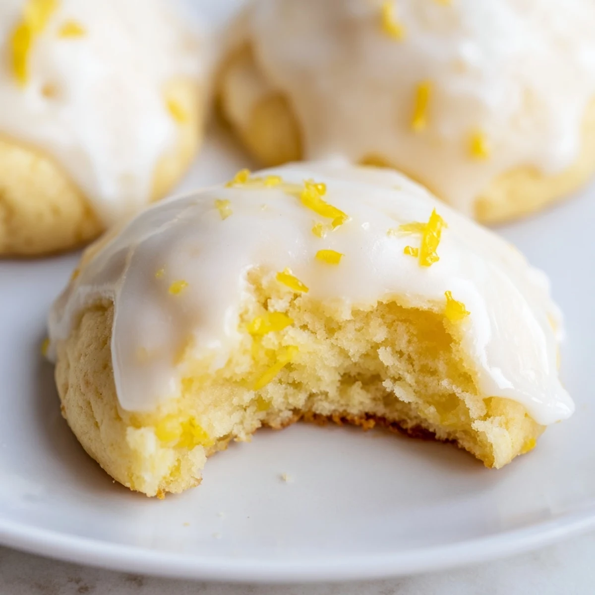 Freshly baked Lemon Ricotta Cookies with Sweet Lemon Glaze rest on a wire cooling rack, drizzled with tangy icing.