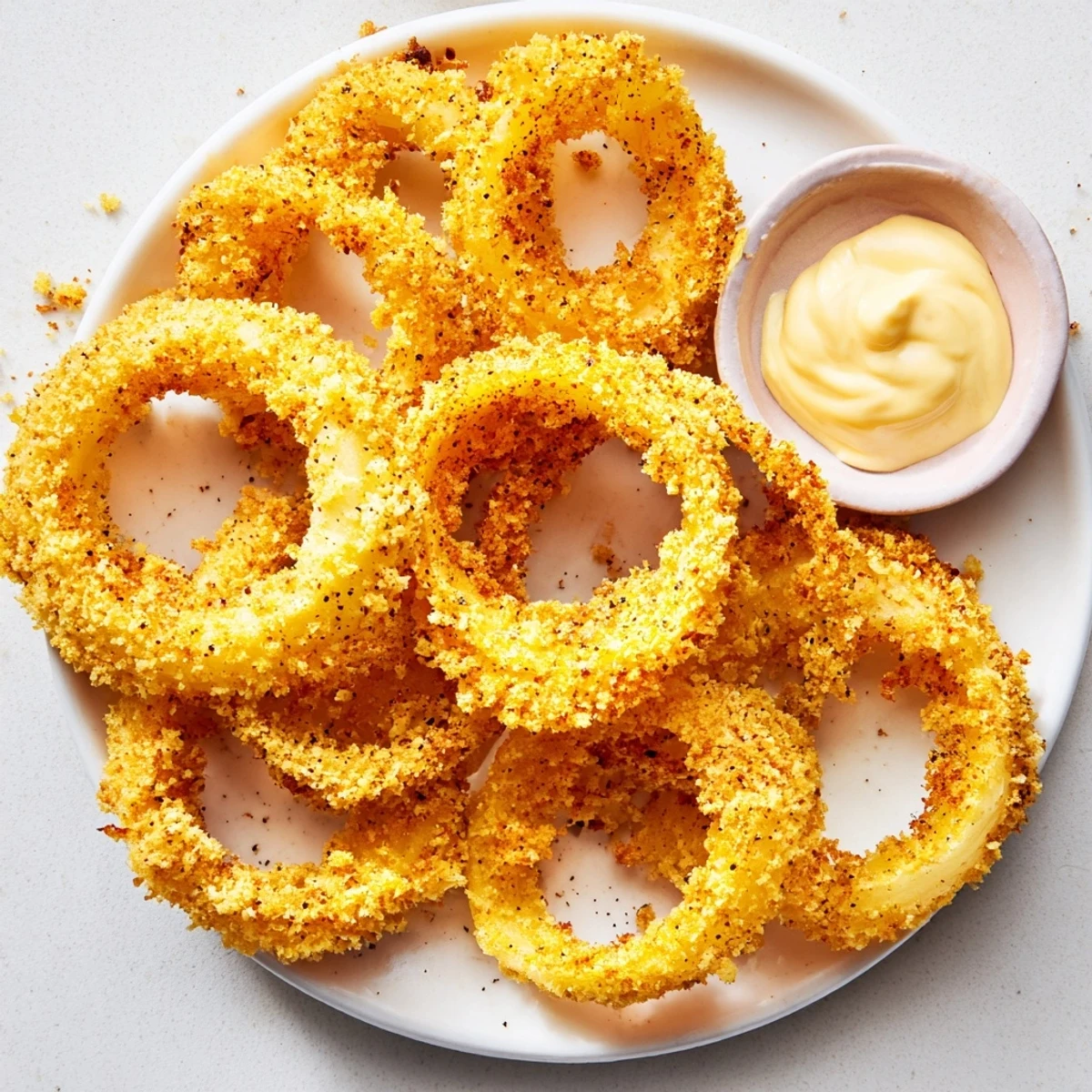 Crispy Air Fryer Onion Rings with Dip are golden and crunchy, served hot with a creamy tangy sauce.