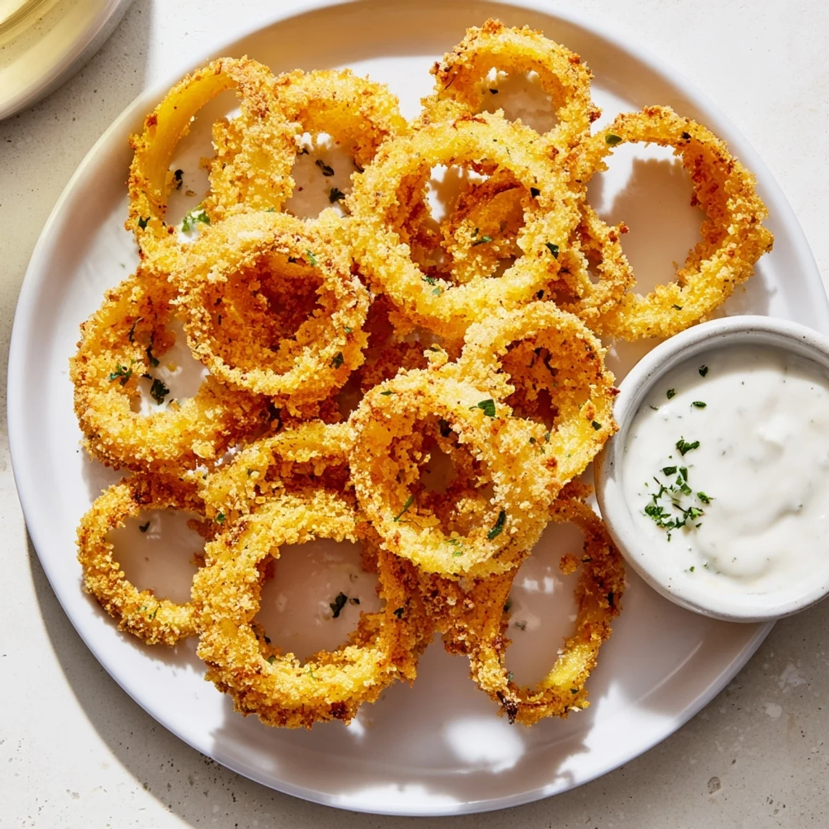 Freshly fried Touchdown Crispy Onion Rings with Ranch, golden-brown and steamy, served hot for game day snacking.