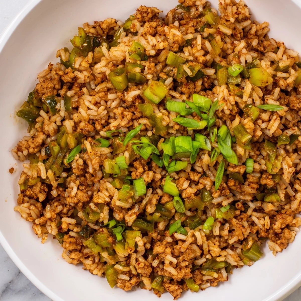 Cajun Dirty Rice with Ground Turkey showcases a hearty skillet of golden rice, green onions, and bold Cajun spices ready to serve.