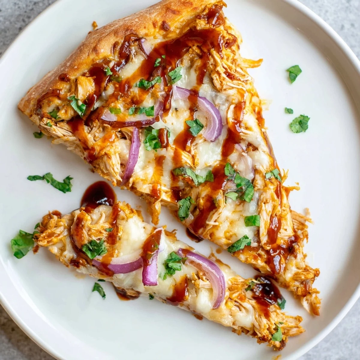 Overhead view of BBQ Chicken Pizza with Red Onion on a rustic board, with fresh cilantro and a drizzle of extra BBQ sauce adding tangy, savory flavor.