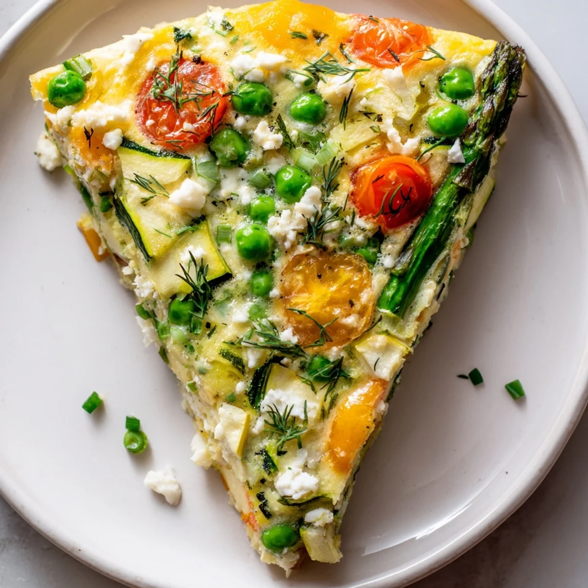 Spring Vegetable Frittata with Herbs baked golden, brimming with peas, spinach, and zucchini on a rustic stovetop skillet.