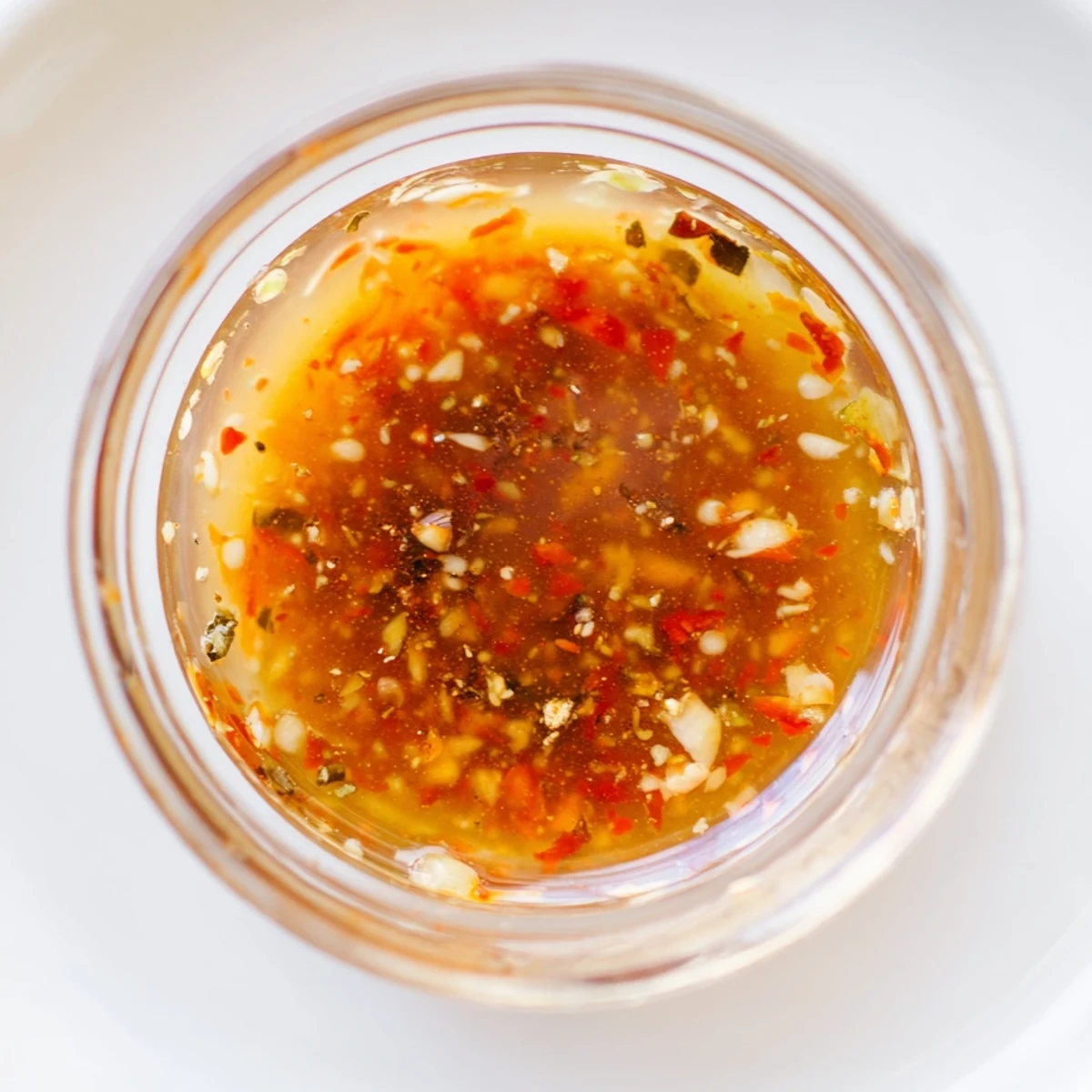 Vibrant Best Asian Coleslaw Dressing drizzled over colorful veggies with a sprinkle of sesame seeds and green onions.