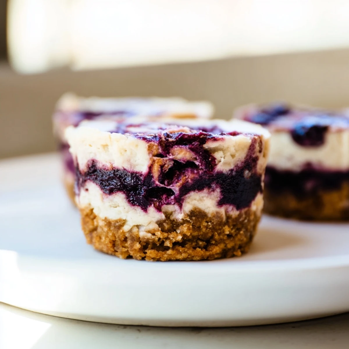 These no-bake Blueberry Cheesecake Protein Bites feature a creamy filling with a vibrant blueberry swirl. 