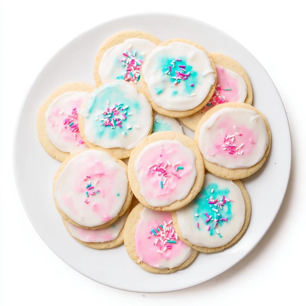 A spoon stirring vibrant pink Sugar Cookie Icing in a bowl, ready for piping intricate cookie designs.