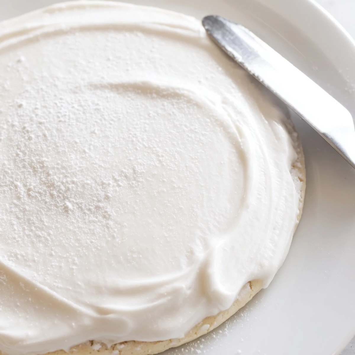 Freshly frosted sugar cookies drizzled with Easy Sugar Cookie Frosting, arranged on a dessert platter for a festive gathering.