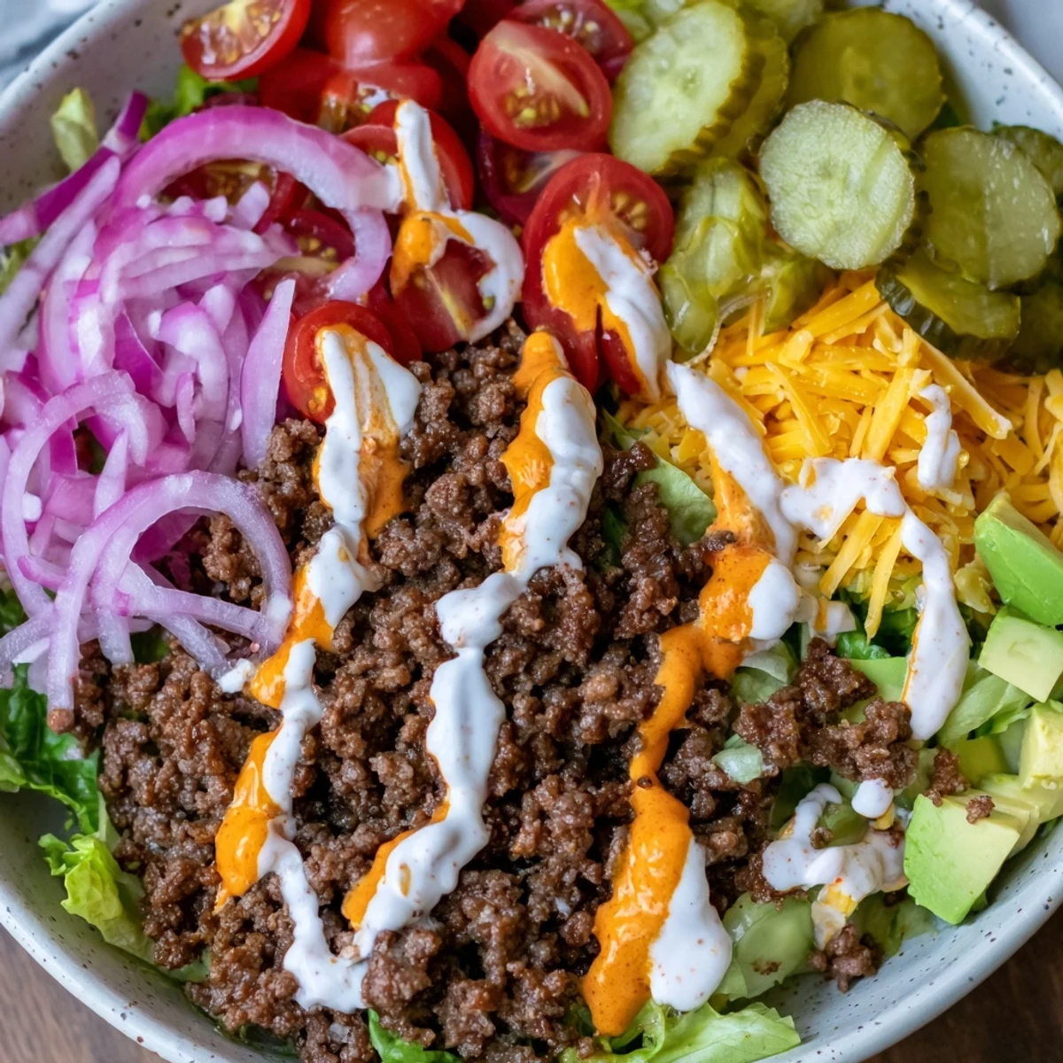 Low carb burger bowl topped with melted cheddar, fresh tomatoes, and creamy special sauce