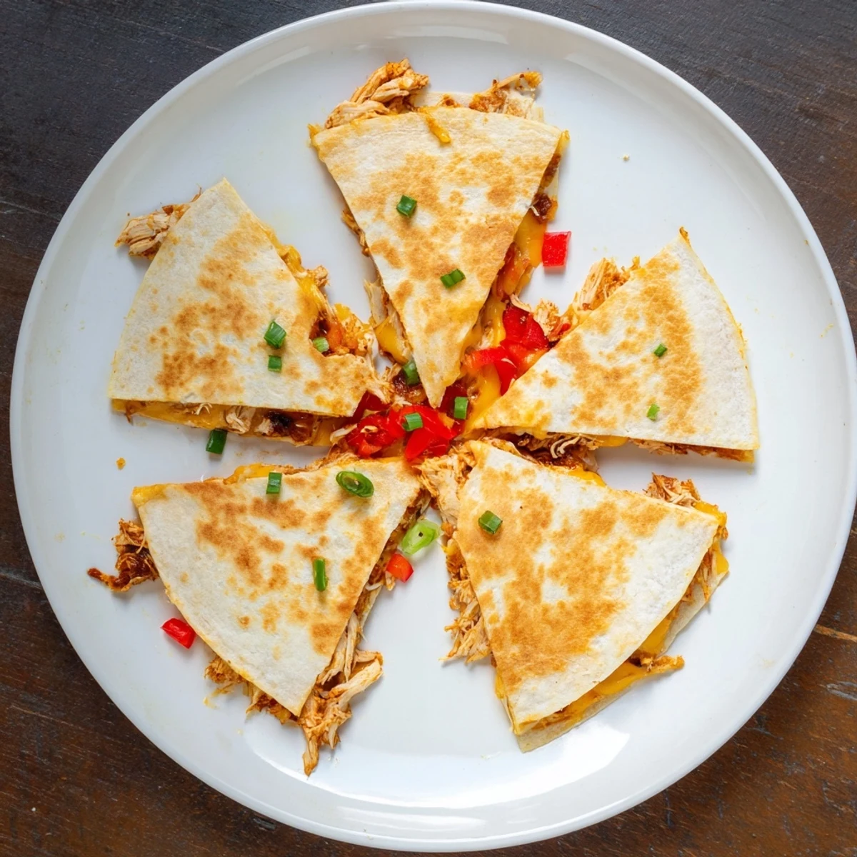 Crispy oven-baked quesadillas cut into wedges revealing melted Mexican cheese and seasoned shredded chicken filling