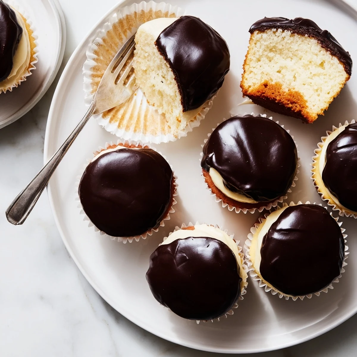 Portable Boston cream pie cupcakes featuring moist vanilla sponge filled with smooth custard and dipped in rich fudge glaze