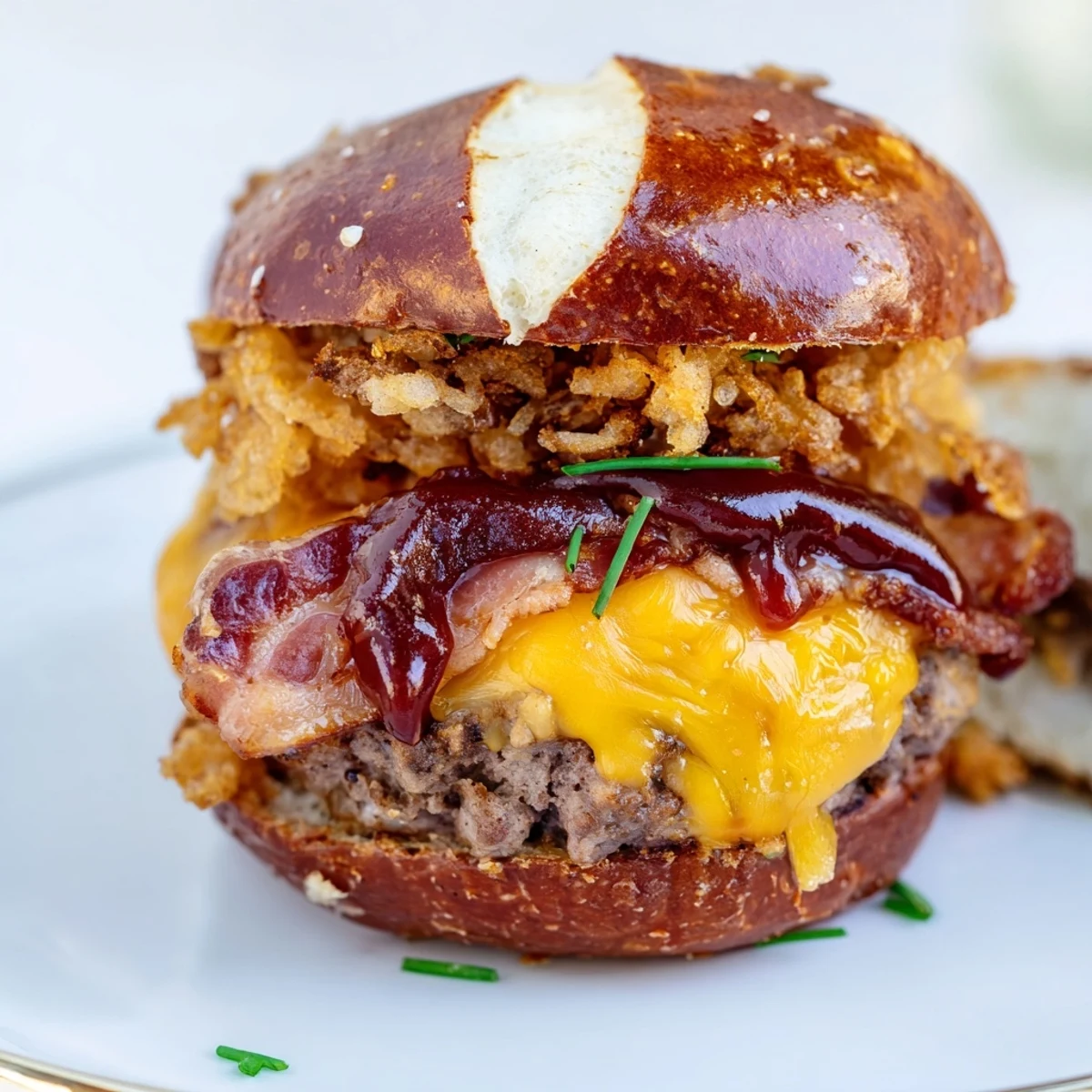 Pretzel Cowboy Sliders featuring grilled beef burgers topped with sharp cheddar cheese, fried onions, and smoky bacon strips