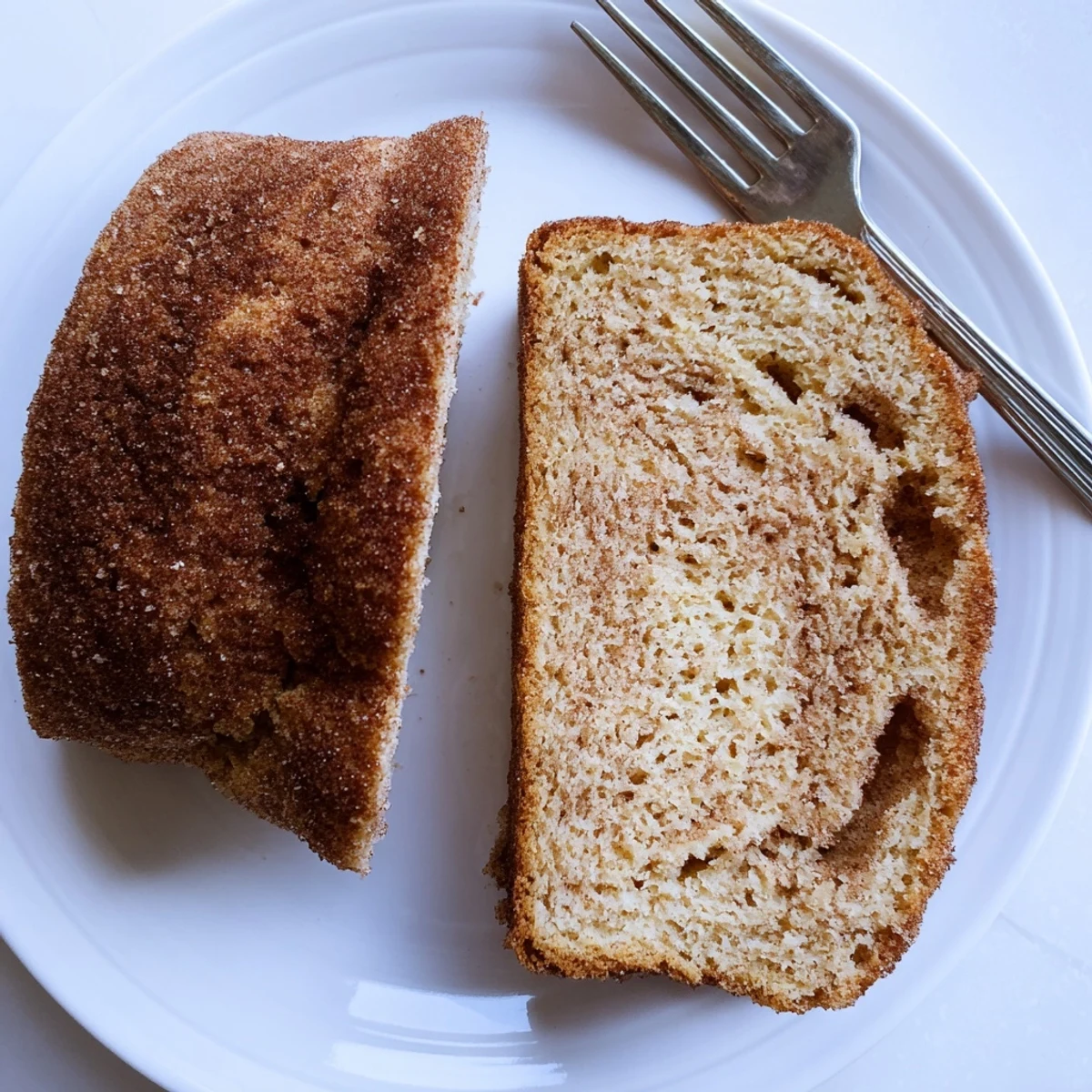 Golden cinnamon sugar donut bread loaf with sweet crunchy coating on a white plate