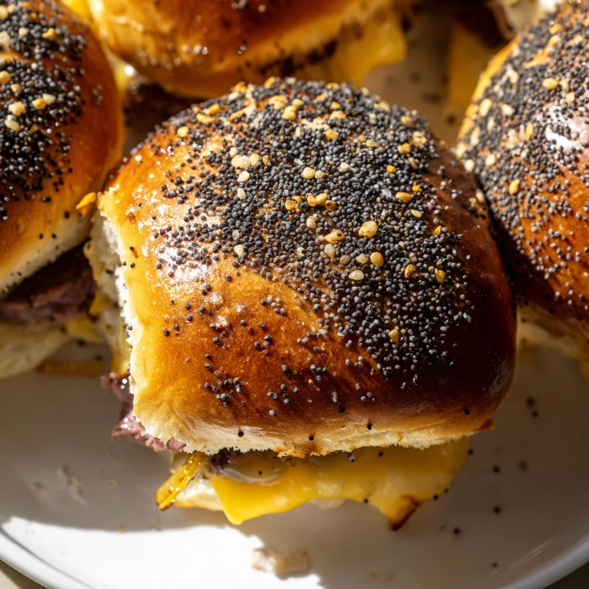 Golden French dip sliders stacked with roast beef, caramelized onions, and melted provolone cheese on toasted buns