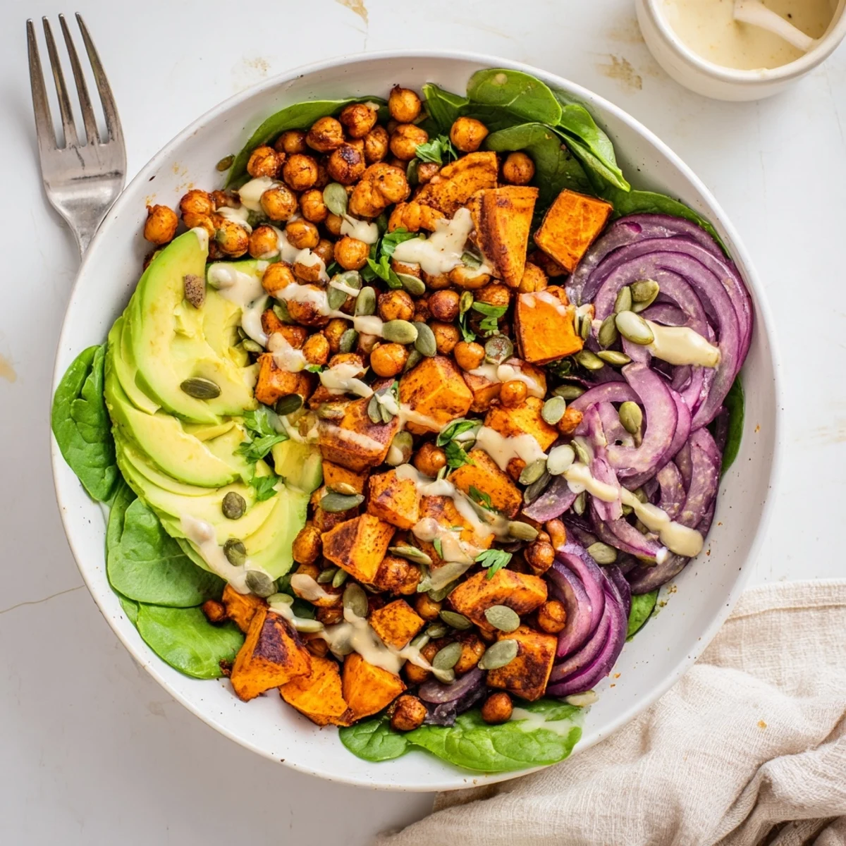 Wholesome roasted sweet potato and chickpea bowls arranged with crisp vegetables and nutty dressing