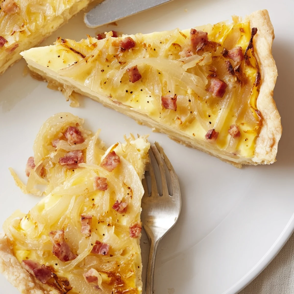 Savory German onion pie tart featuring creamy custard filling and golden brown onions on buttery crust