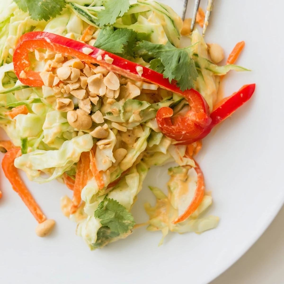 Fresh vegetable bowl topped with creamy Thai peanut sauce and crunchy roasted peanuts