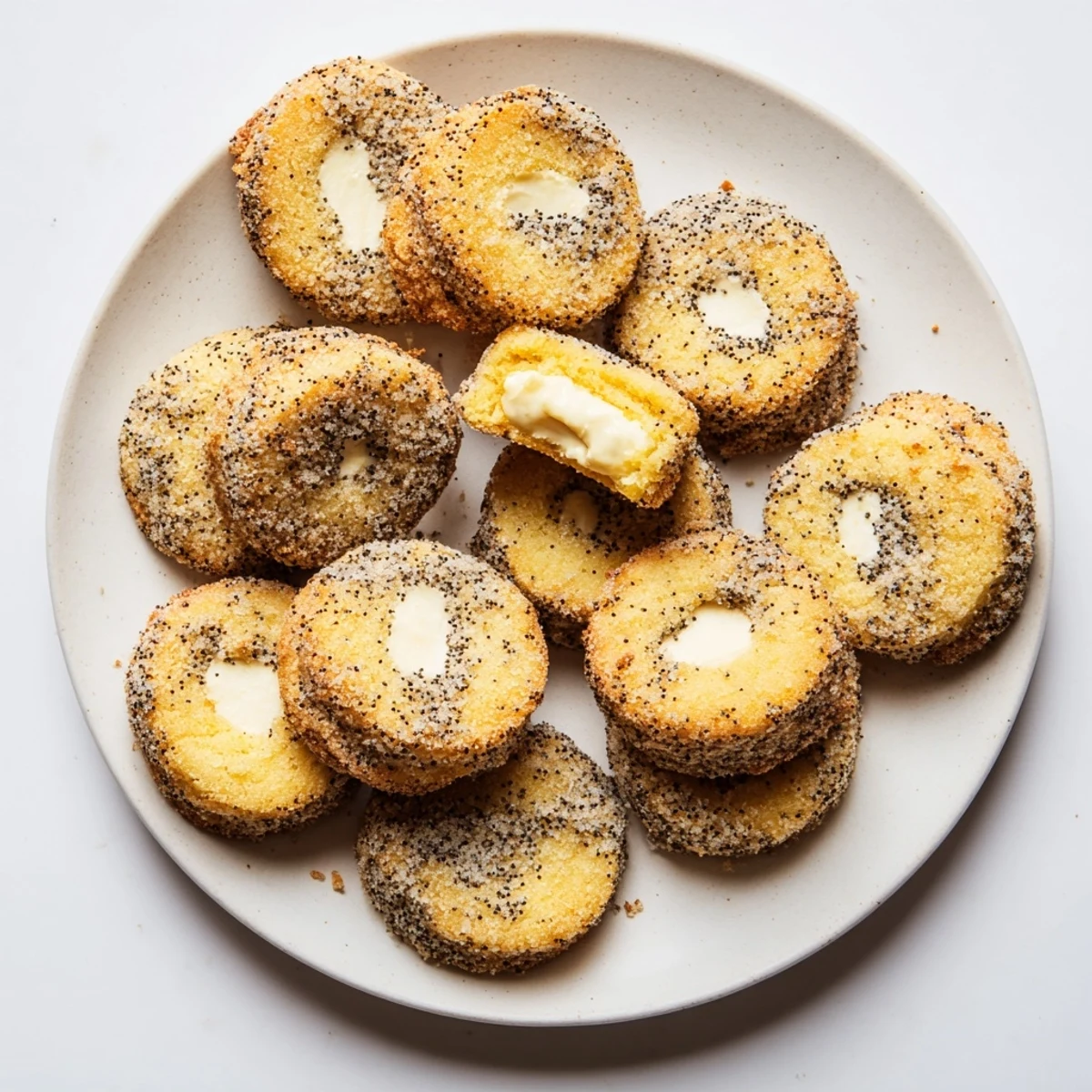 Golden lemon poppy seed cheesecake cookies with creamy centers and sugary coating