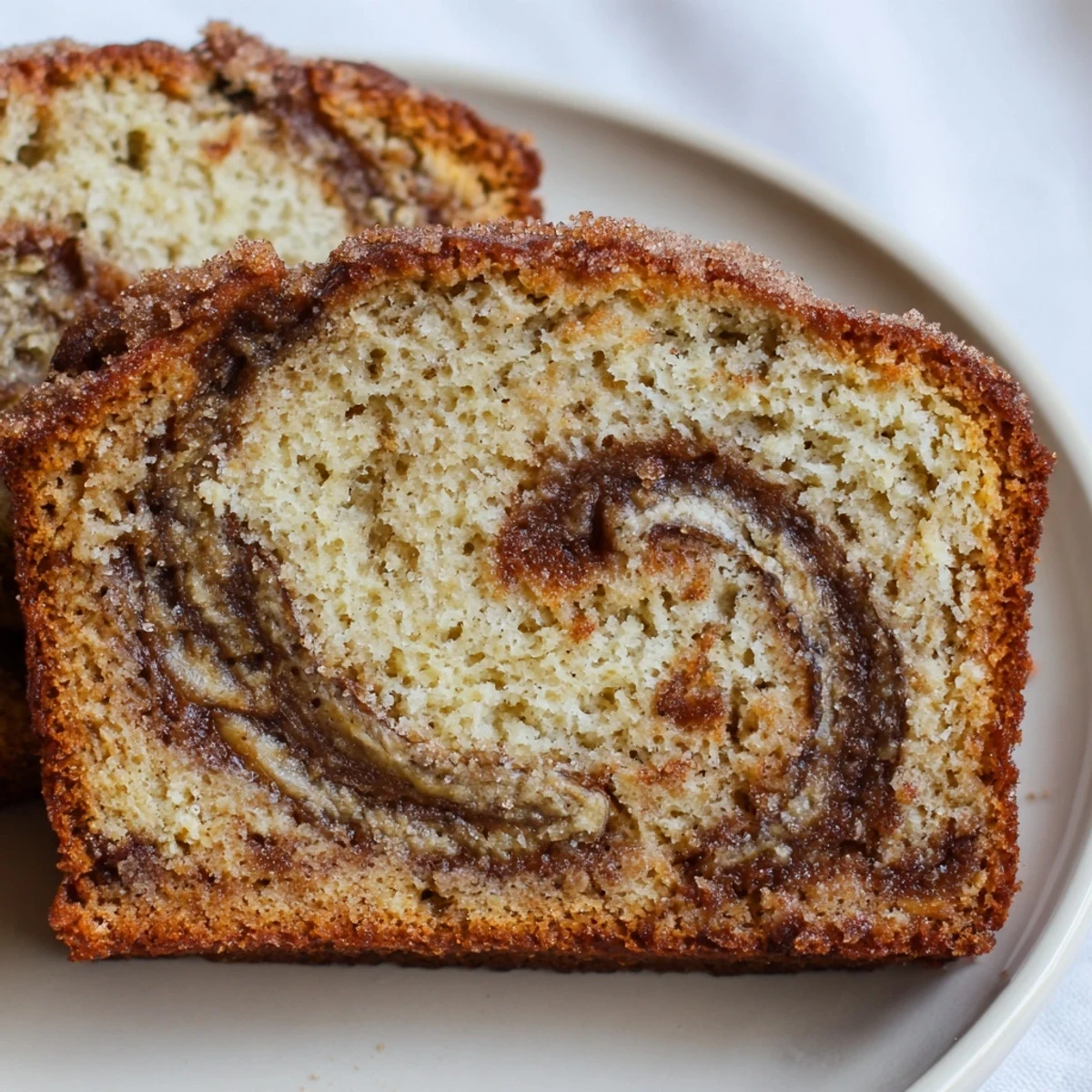 Sliced Cinnamon Sugar Swirl Banana Bread served on rustic wooden board with steam rising from warm loaf