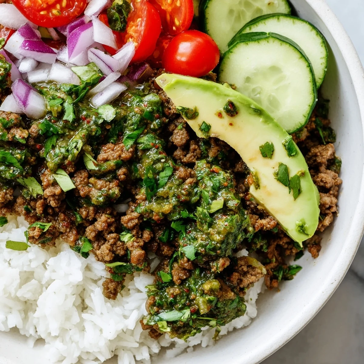 Zesty chimichurri ground beef bowls loaded with crisp cucumbers tomatoes and tender seasoned meat
