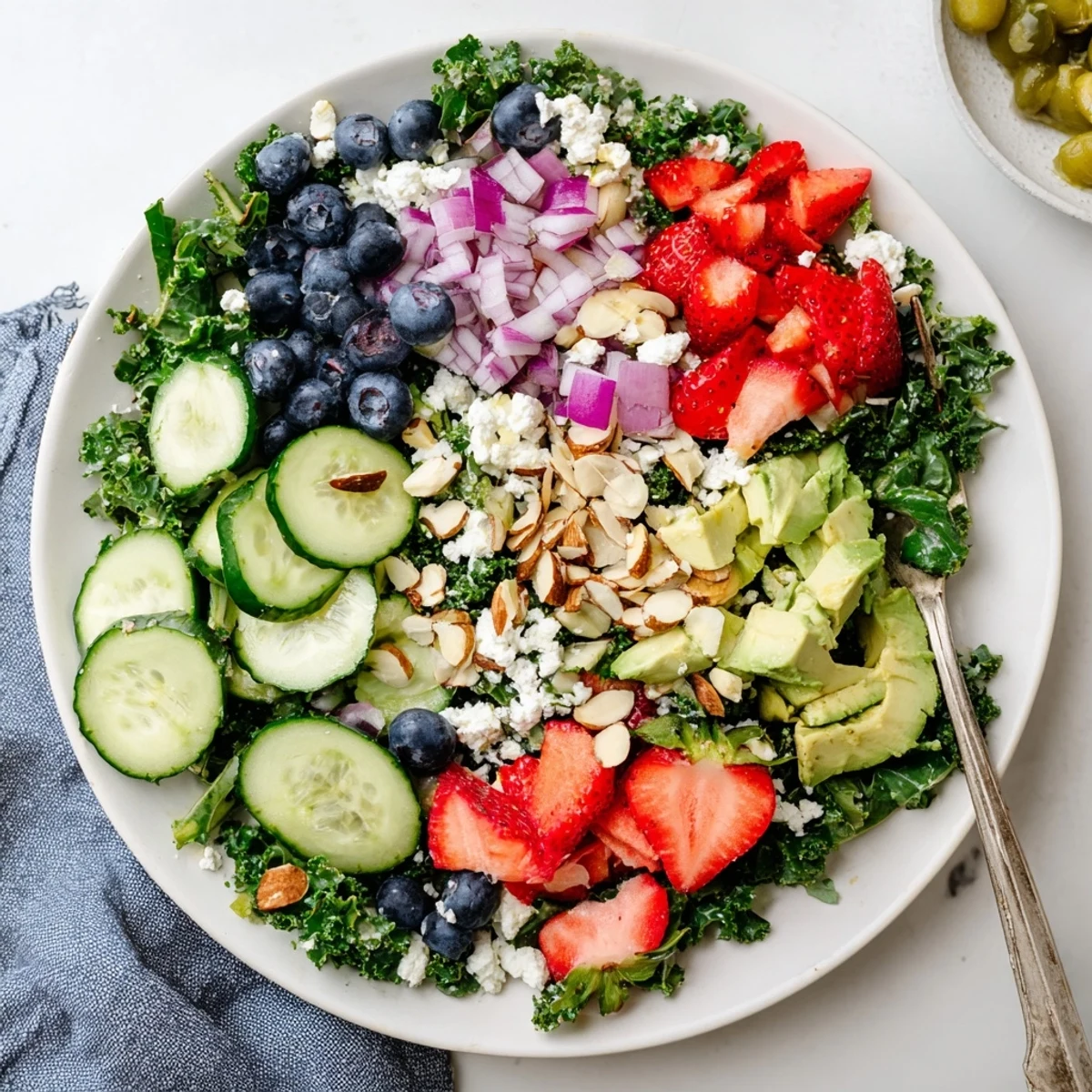 Hearty kale tossed with juicy berries and avocado in a lemon-honey vinaigrette