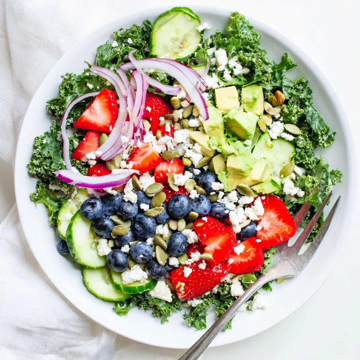 Crisp summer kale salad bowl with blueberries, cucumber, and crunchy sliced almonds