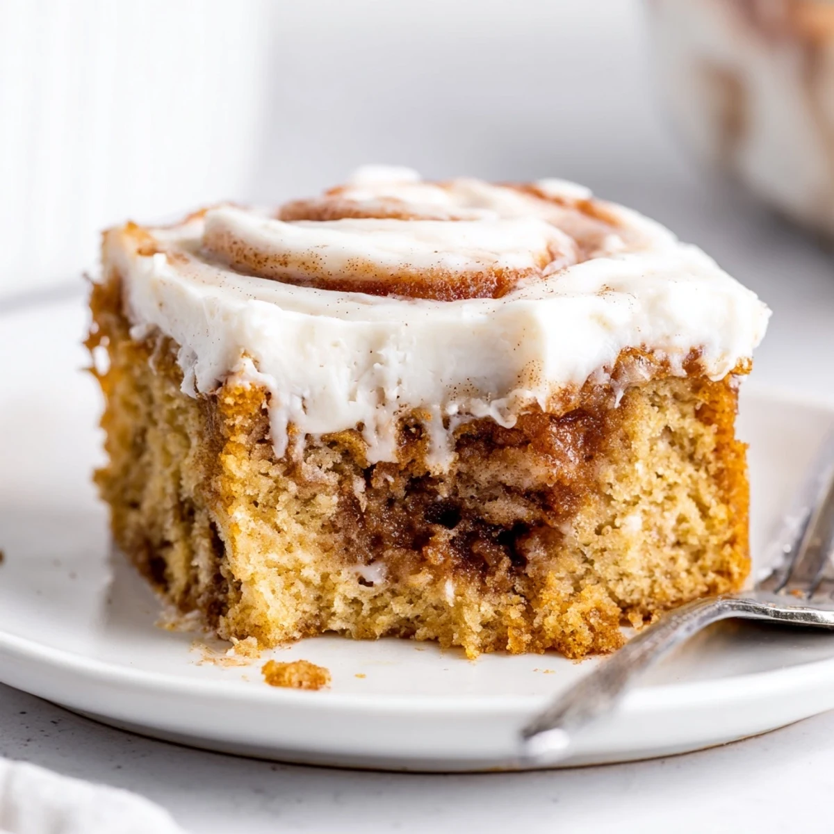 Cinnamon Roll Poke Cake with gooey cinnamon pockets and cream cheese frosting