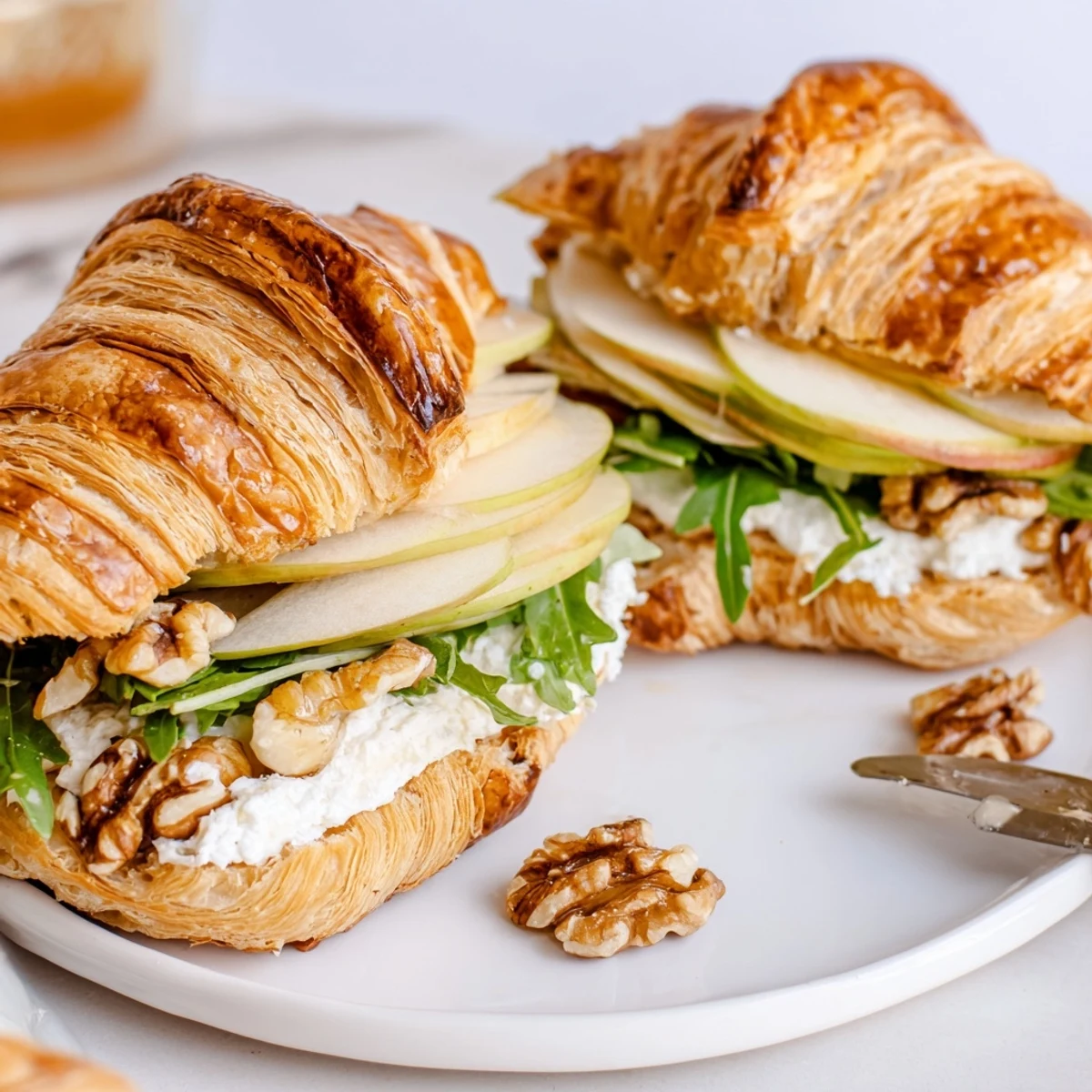 Fresh Apple Goat Cheese Croissant Sandwich served open faced, creamy cheese melting slightly