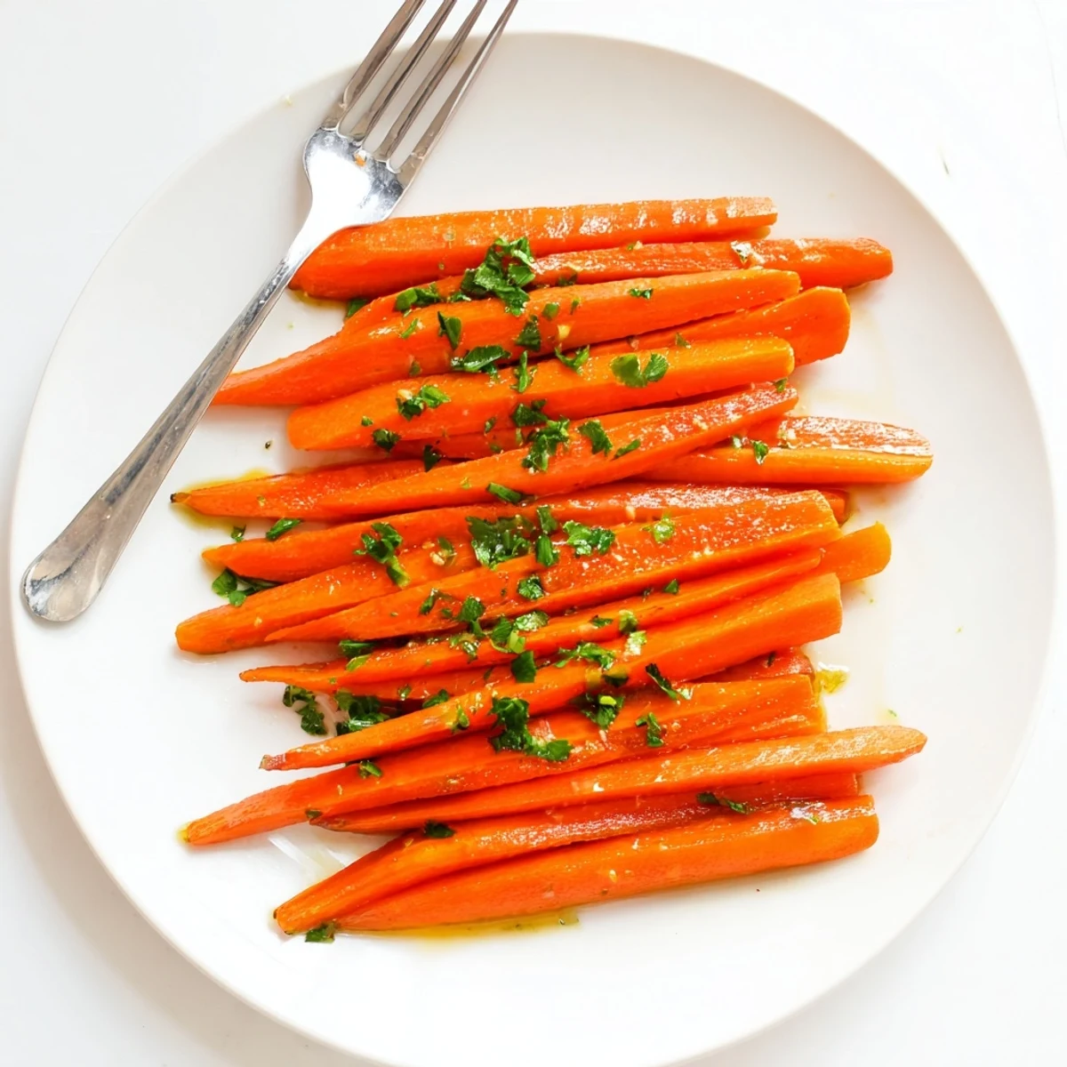 Tender caramelized carrot sticks coated in sweet sticky honey glaze on a rustic platter