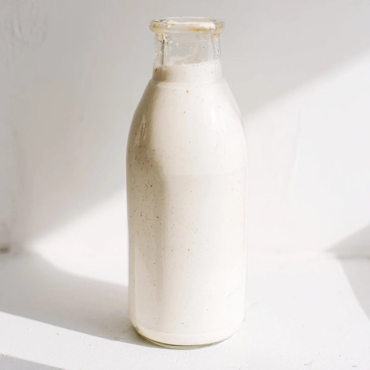 Glass jar filled with creamy white homemade coconut milk ready for recipes