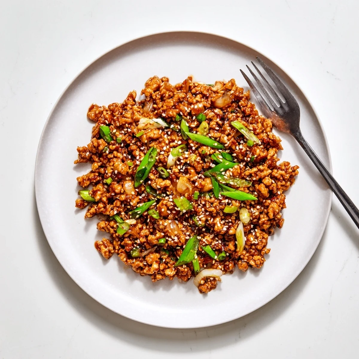 Golden brown ground chicken coated in a glossy sweet and spicy General Tso's sauce