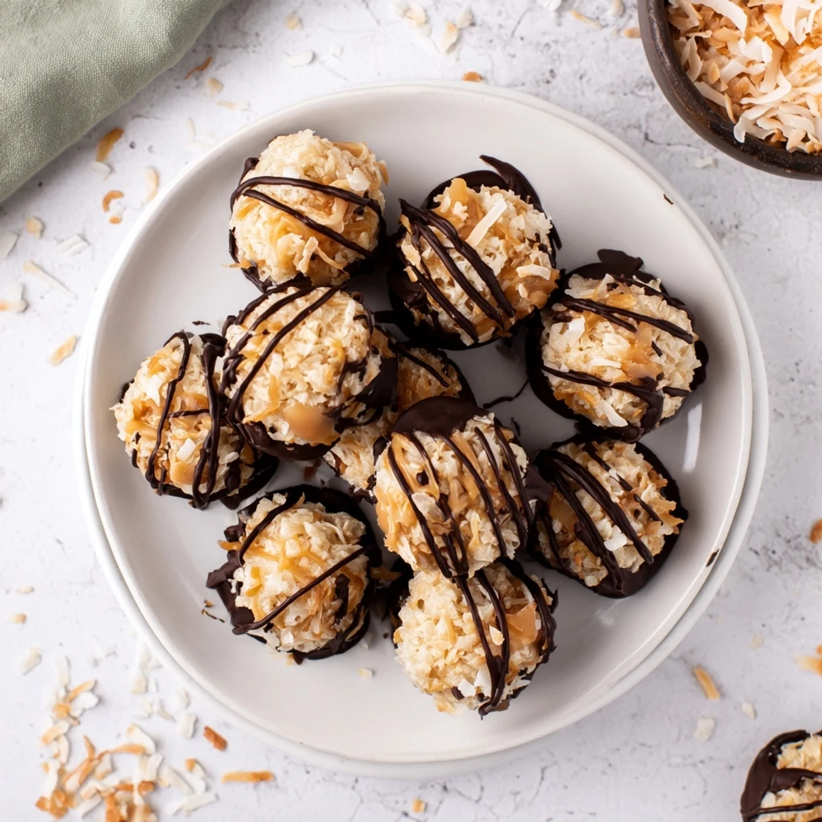 Chocolate-dipped no bake Samoa bites with toasted coconut and creamy caramel filling on parchment paper