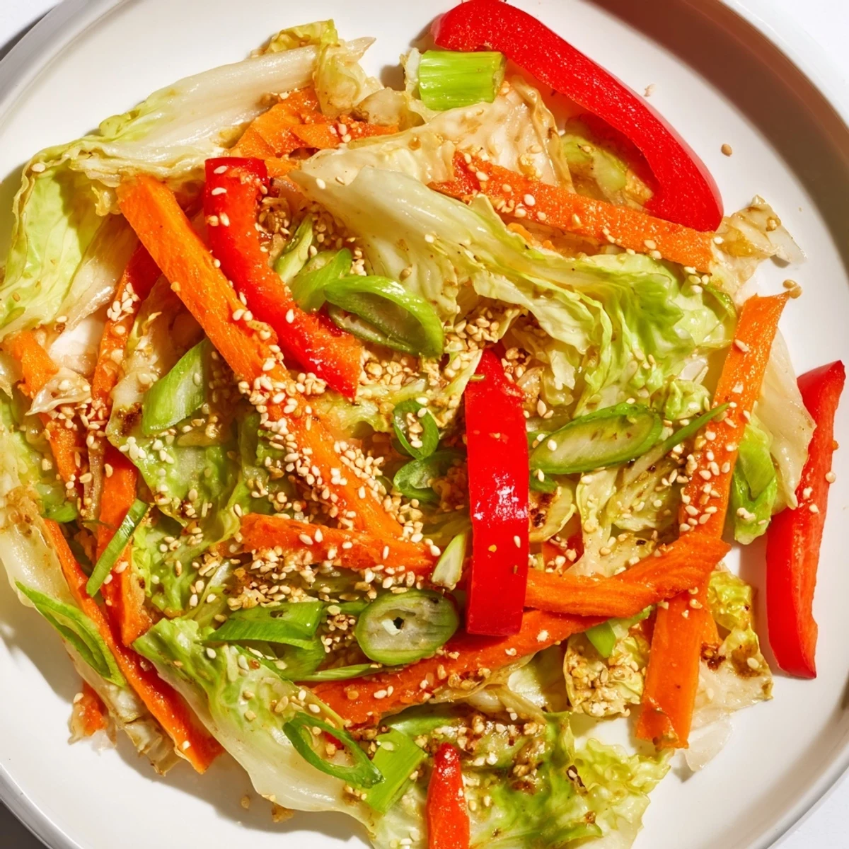 Hearty cabbage stir fry recipe featuring vibrant bell peppers and carrots in wok