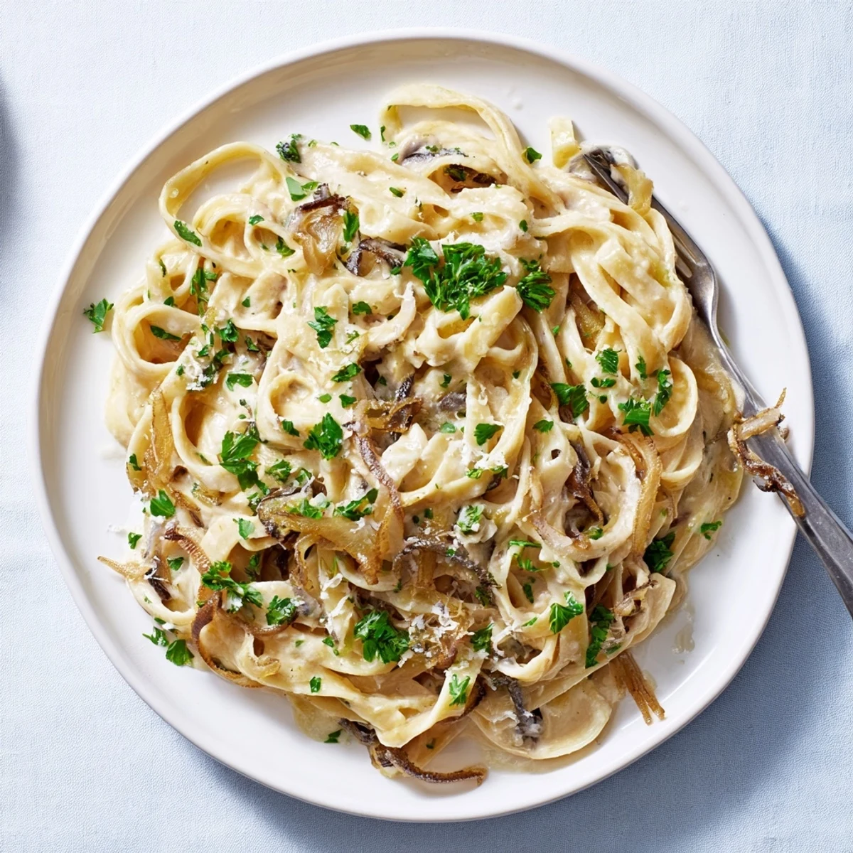 Golden brown caramelized onions coat creamy fettuccine noodles in this rich vegetarian pasta dish
