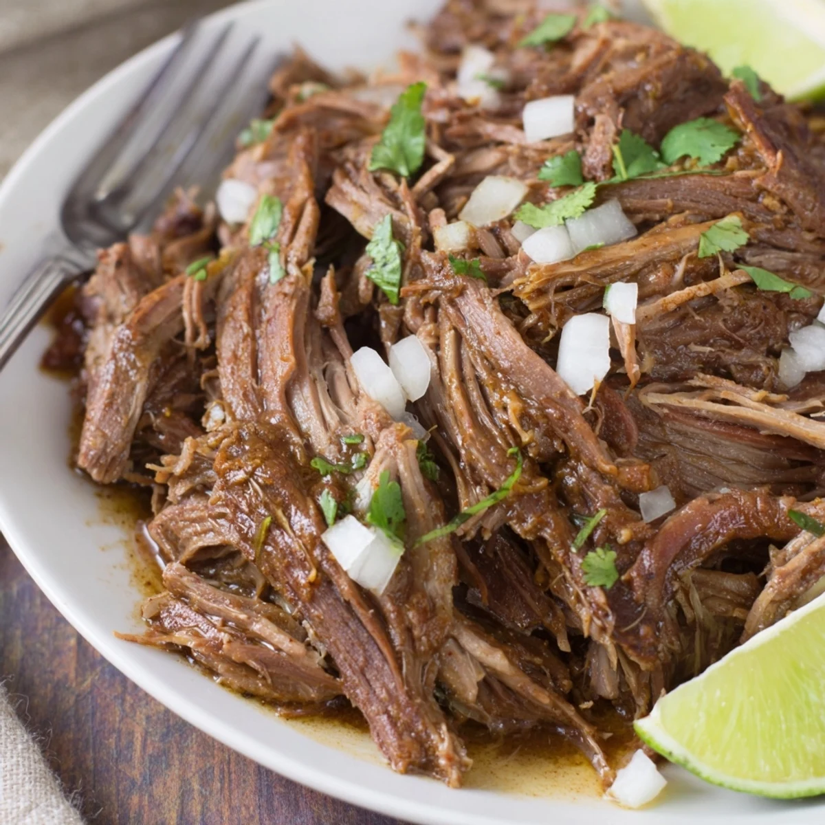 Slow Cooker Beef Barbacoa piled on tortillas, steaming, tender, smoky aroma.