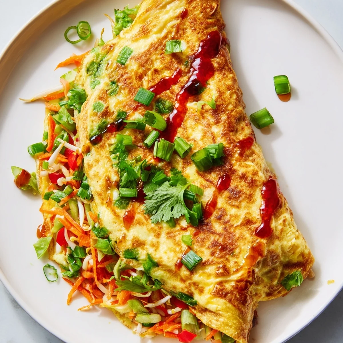 Fluffy Chinese omelette folded over colorful bell peppers, bean sprouts, and shredded carrots, garnished with cilantro.