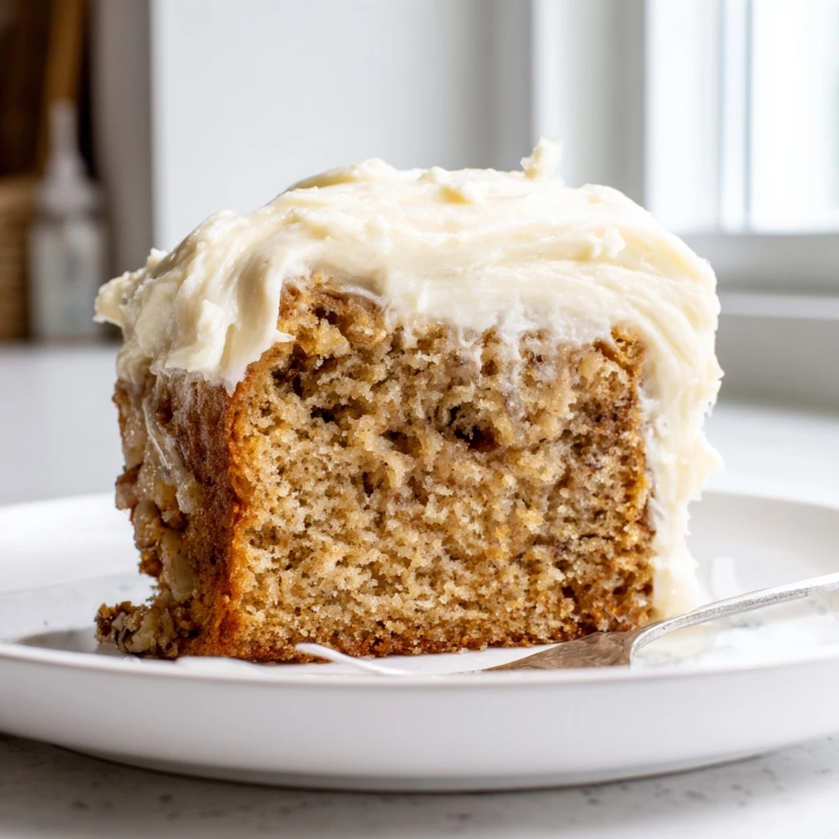 Golden brown butter banana cake topped with generous swirls of cream cheese frosting