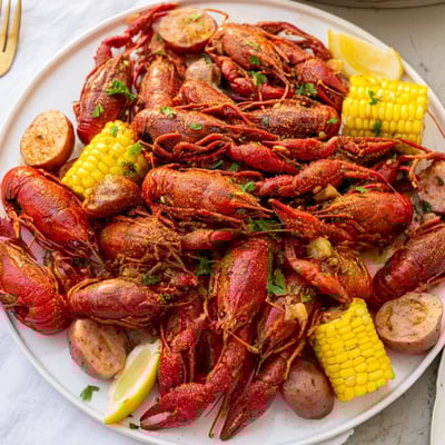 Freshly boiled Louisiana Style Crawfish Boil with bright red crawfish, corn, potatoes, and smoked sausage.