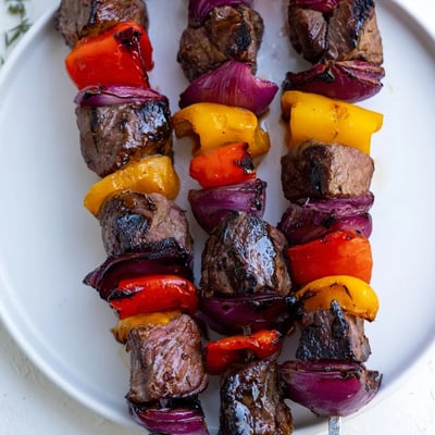 Colorful skewers of marinated Beef Kebabs with Bell Peppers and Onions served over fluffy rice.