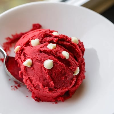 Bright red velvet cookie dough bites dusted with cocoa on a rustic plate